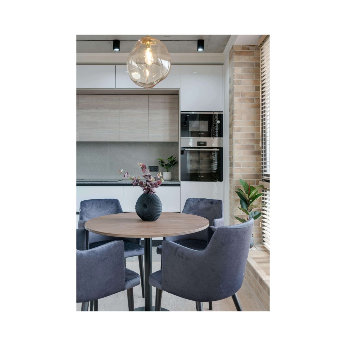 Contemporary dining space featuring a round table, upholstered chairs, and stylish decor.